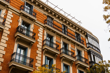 Obraz premium Charming residential building in Madrid featuring classic balconies and elegant architecture.