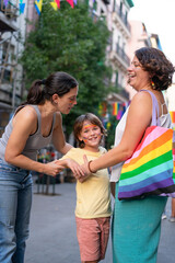 Mothers holding hands with son at pride parade celebrating lgbtq+ rights