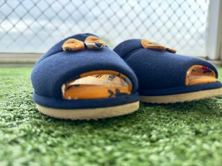 Conforto com charme! Chinelos de tecido azul com laço amarelo em relva sintética ideais para...