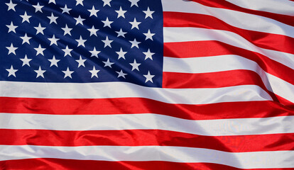 Fototapeta premium Close-up of the national flag of The United States, fluttering in the wind with folds, wave pattern