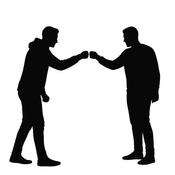 Two men silhouettes fist bumping greeting