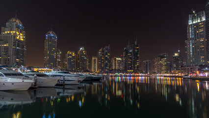 Fototapeta premium Dubai marina bay with yachts an boats night timelapse hyperlapse