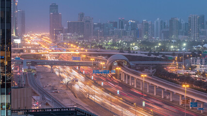 Obraz premium Aerial view of Jumeirah lakes towers skyscrapers day to night timelapse with traffic on sheikh zayed road.