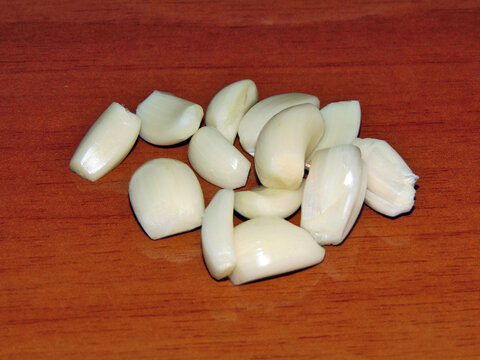 several pieces of garlic on a wooden background