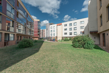 Modern Apartment Building With Outdoor Playground Area Under Bright Sky