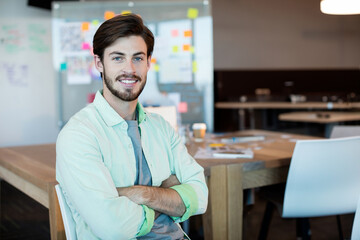 Laptop resting on wooden desk in modern office, featuring colorful whiteboard notes and coffee cup © wavebreak3