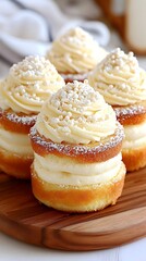 Four layered vanilla cakes with creamy frosting and a dusting of sugar crystals on a wooden board