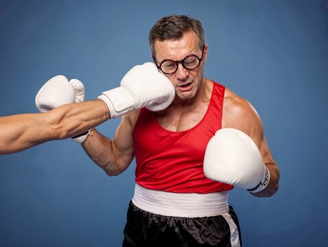 Middle-aged boxer getting hit in the face during match, a humorous and exaggerated moment.