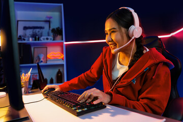 Host channel of smiling beautiful Asian girl streamer playing online game wearing headphone talking...