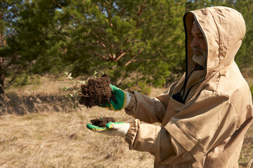 Tick season in the forest. An adult man (biologist, soil scientist, ecologist) in an...
