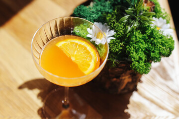 Refreshing orange cocktail. Glass with fruit drink. Summer drink on the table. Citrus slice...