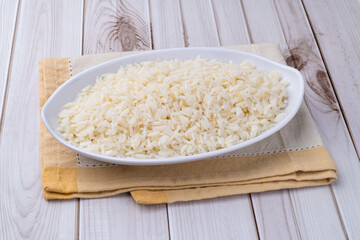 Cooked white rice in a plate over wooden table