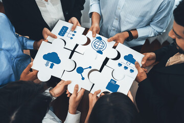 Diverse corporate officer workers collaborate in office, connecting puzzle pieces to represent...