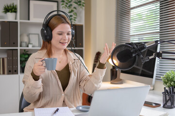 A female podcaster is recording in a quiet studio.