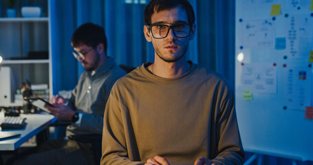 Team adult male freelance developer work late typing write prompt AI bot app program nomad terminal code at office night. Artificial intelligence dashboard, robotics, user interface, machine learning.