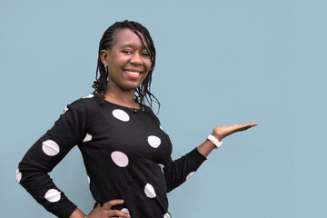 Smiling African Woman Presenting and Pointing on Light Gray Background