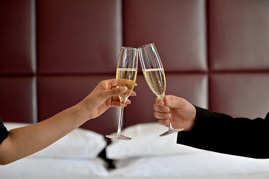 Elegant champagne toast celebration with crystal flutes. Luxury sparkling wine cheers for romantic dinner, wedding, anniversary or special event.