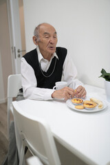 Elderly man enjoying breakfast and conversation at home