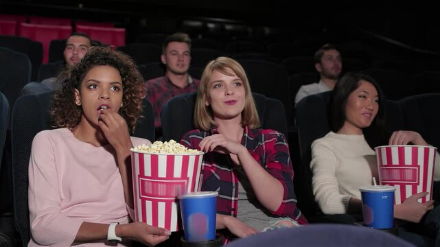 Excited group of young friends enjoying a movie night in a multiplex