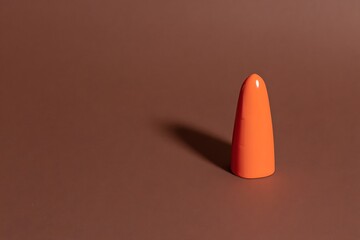 Orange cone on brown studio surface