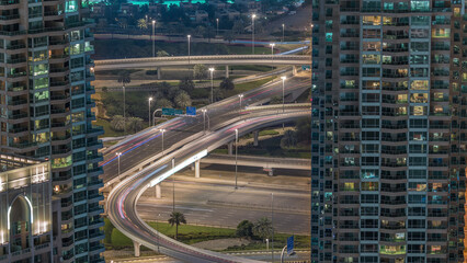 Dubai Marina highway exit between skyscrapers, spaghetti junction aerial night timelapse