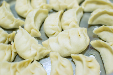 Close up of Momo, type of South Asian dumpling; native to Tibet, Nepal, Bhutan and Sikkim. It is similar to Chinese baozi and jiaozi, Mongolian buuz, Japanese gyoza and Korean mandu. Stock photograph.