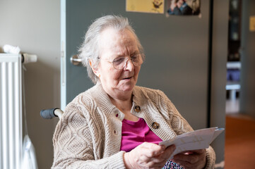 Expressive portrait of an 86 yo grandmother sitting in a wheelchair home in Tienen, Flemish...