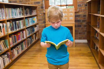Green book lying open on polished wood floor in exposed brick library with wooden card catalog