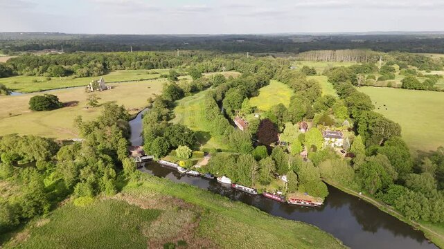 Drone footage of River Wey flowing in England rural countryside on a sunny day in Surrey
