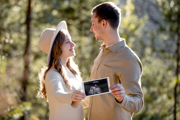 A Couple Joyfully Celebrating Their Pregnancy Announcement Surrounded by Beautiful Nature