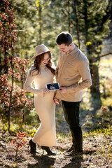 A Couple Joyfully Celebrating Their Pregnancy Announcement Surrounded by Beautiful Nature