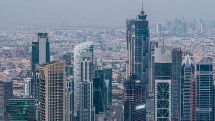 Obraz premium Dubai Downtown skyline futuristic cityscape with many skyscrapers and Burj Khalifa aerial night to day timelapse.