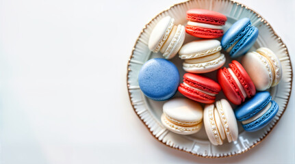 Top Down View of Plate with Festive Macarons Decorated in Colors of French Flag on White Clean Empty Surface with Mock Up Space 