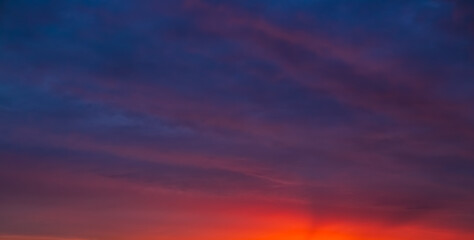 Naklejka premium Evening sky with deep purple and orange hues against the setting sun