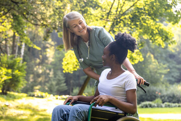 Nurse and a female on a wheelchair in the park