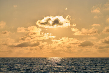 Serene golden sunset casts warm glow over peaceful ocean horizon, creating a tranquil ambiance....