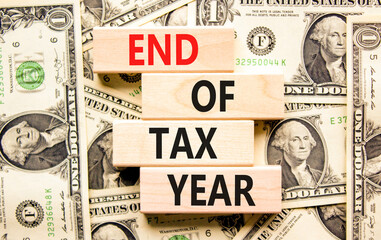 End of tax year symbol. Concept words phrase End of tax year on beautiful wooden blocks. Dollar...