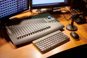Professional audio mixing console, two monitors and microphone, essential tools for sound recording...