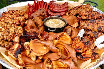 Hearty country lunch for a holiday. Meat feast. Pig ears, kebabs, sausages. meat.