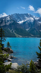 Breathtaking view of a turquoise lake surrounded by majestic snow-capped mountains.