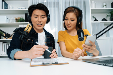Smiling radio influencer hosts wearing headphones with channel social media online live streaming...