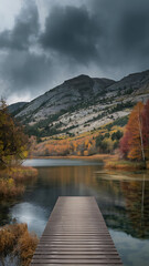 Scenic autumn landscape featuring a wooden pier extending over a calm lake towards mountains.