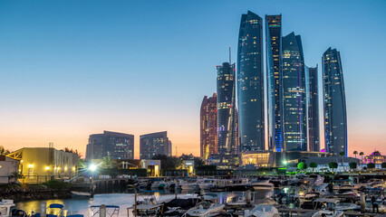 Fototapeta premium Al Bateen marina Abu Dhabi day to night timelapse with modern skyscrapers on background