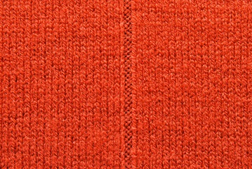 Red wool jersey fabric texture with a seam in the center as background