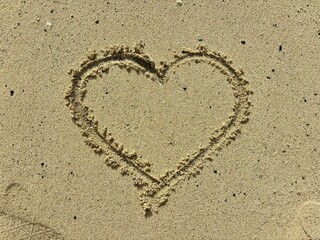 Heart in the yellow sand isolated close-up in Fuerteventura, Canary Islands, Spain, romantic vacations