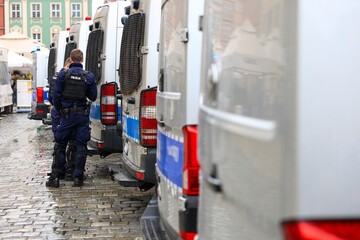 Policjanci prewencji przy radiowozie w mundurach na służbie. © FotoDax