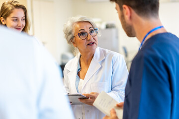 Senior doctor explaining diagnosis to medical team in hospital