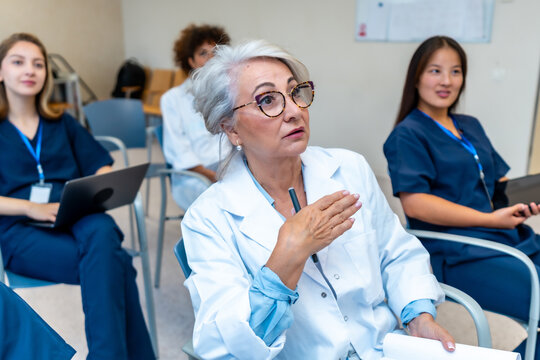 Senior doctor leading medical conference, explaining with hand gestures - Powered by Adobe