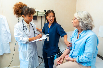 Doctor and nurse measuring blood pressure of senior patient in hospital room