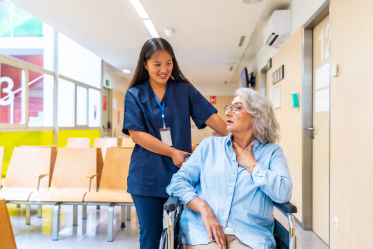 Fototapeta Nurse assisting senior woman with breathing difficulties in hospital corridor